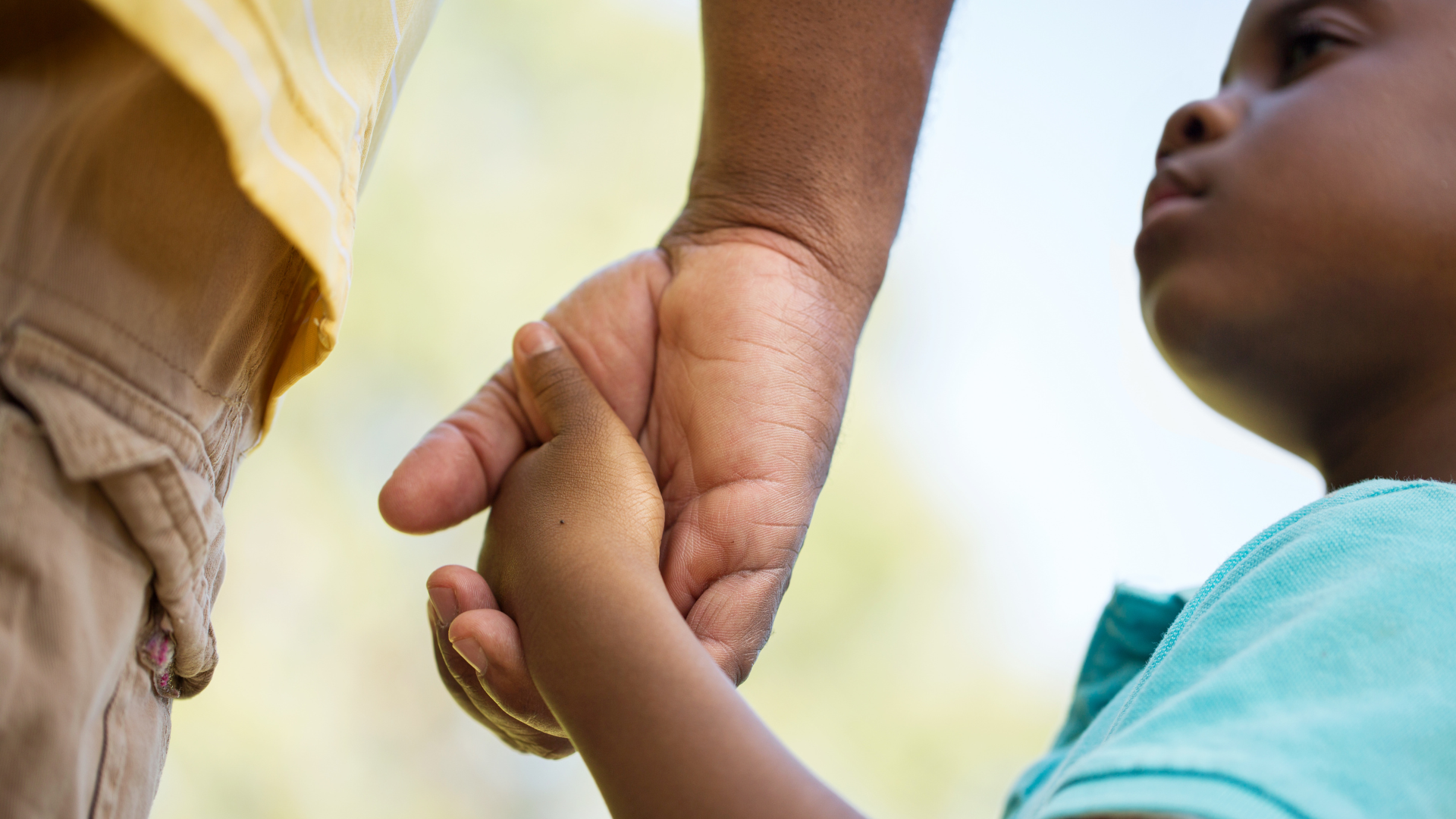 Child holding hands with a parent for reassurance
